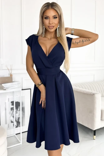 Na zdjęciu widoczna jest elegancka, rozkloszowana sukienka Scarlett w głębokim granatowym kolorze, która podkreśla talię i ma dekolt w kształcie litery V. Sukienka Scarlett jest idealna na wieczorne wyjścia, łącząc klasyczny krój z nowoczesnym stylem.}