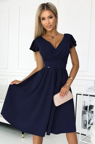 Na zdjęciu widoczna jest elegancka sukienka Matilde w głębokim granatowym kolorze, charakteryzująca się kopertowym dekoltem i krótkimi rękawami. Sukienka Matilde ma rozkloszowany dół, który dodaje jej lekkości i kobiecego uroku.}
