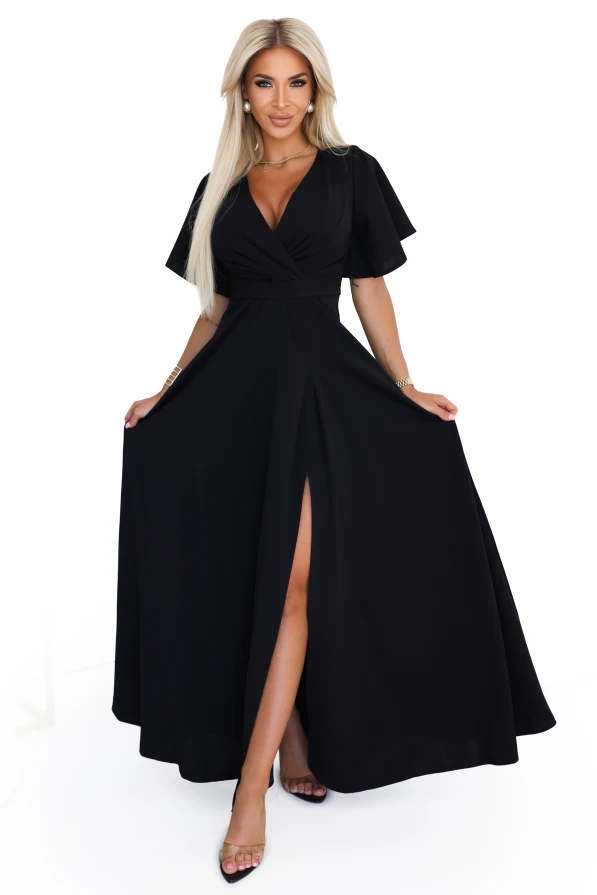 Modelka w eleganckiej czarnej sukni maxi z kopertowym dekoltem i rozcięciem na nodze, prezentująca wieczorową stylizację od polskiego producenta sukienek Numoco.