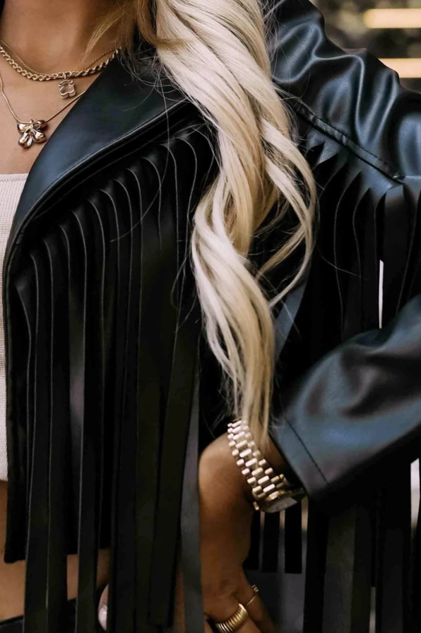 Modelka prezentuje czarną ramoneskę z frędzlami Numoco Basic, łącząc elegancję z nutą rockowego stylu w miejskiej scenerii.