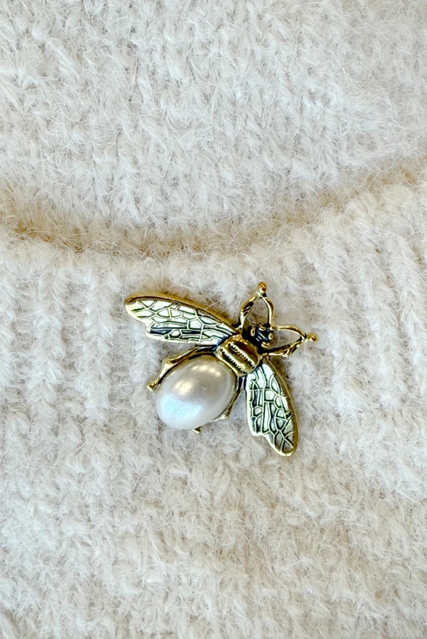 Kardigan damski w kolorze beżowym z dzianiny, modny i wygodny, z kieszeniami i detalami dodającymi szyku – produkt Numoco Basic.