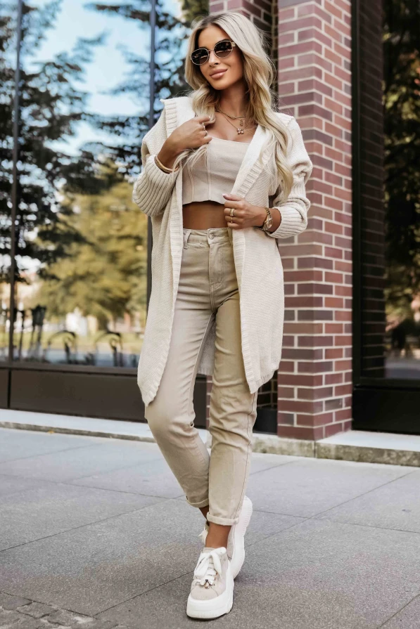 Modelka prezentuje długi beżowy kardigan z kapturem marki Numoco Basic w jesiennej stylizacji.